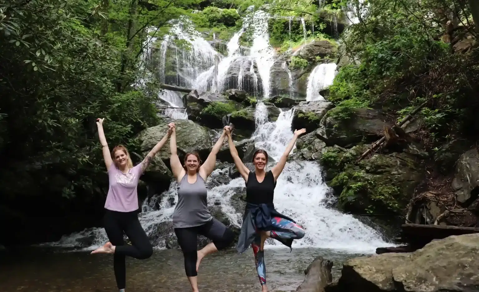 Yoga Angels students in tree pose at a waterfall
