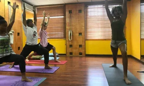 A group practising in a studio with wall-mounted yoga ropes, from the existing client photo collection